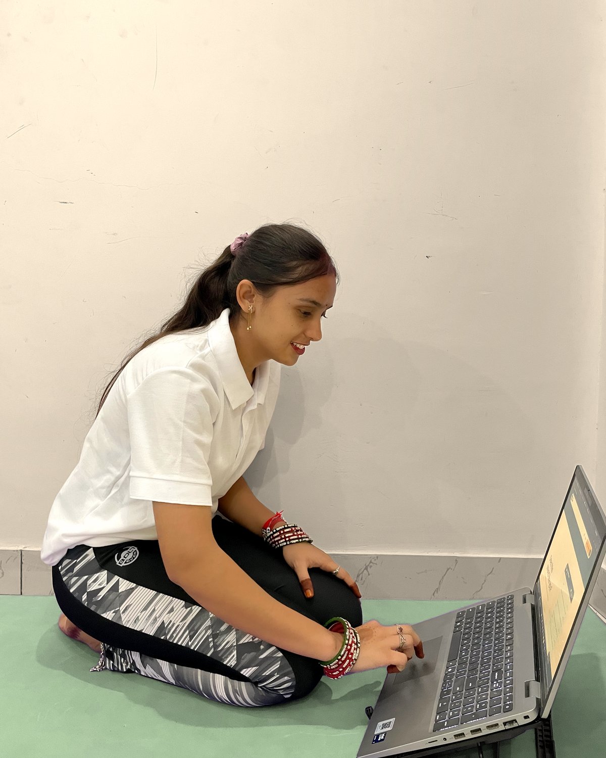 Latika laptop camera par live online yoga class sikhate hue